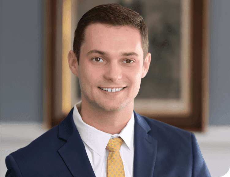 A man in a suit and tie smiling for the camera.